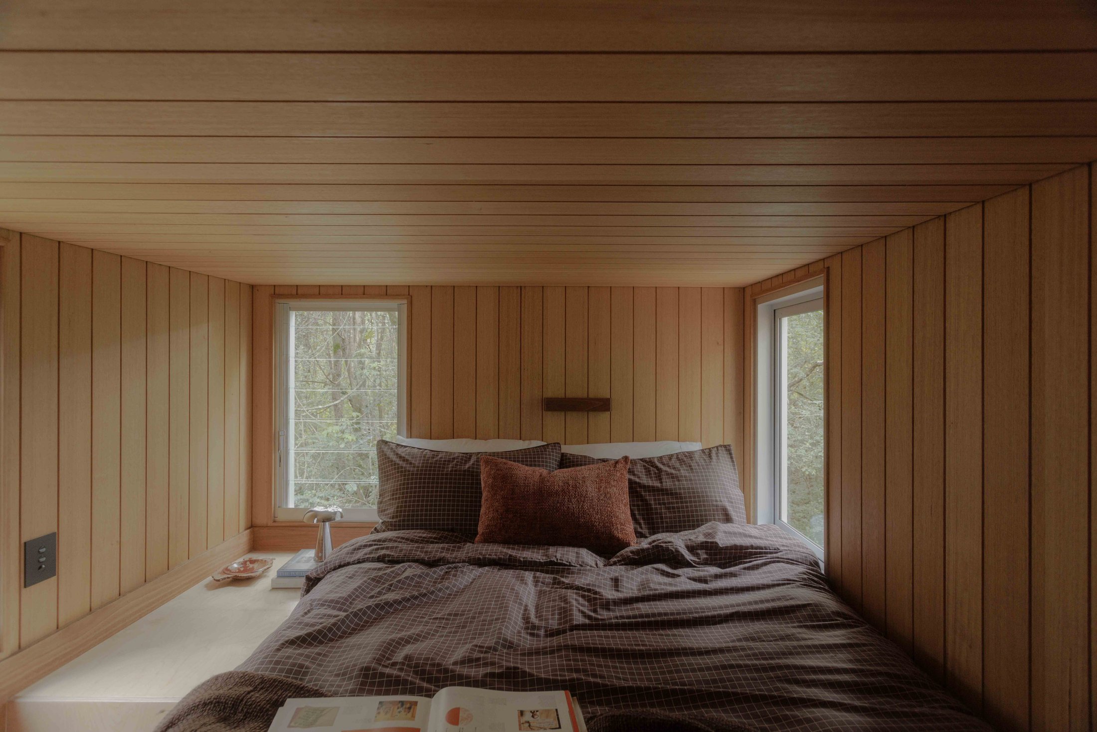Loft bedroom with Tasmanian oak lined ceiling and queen bed