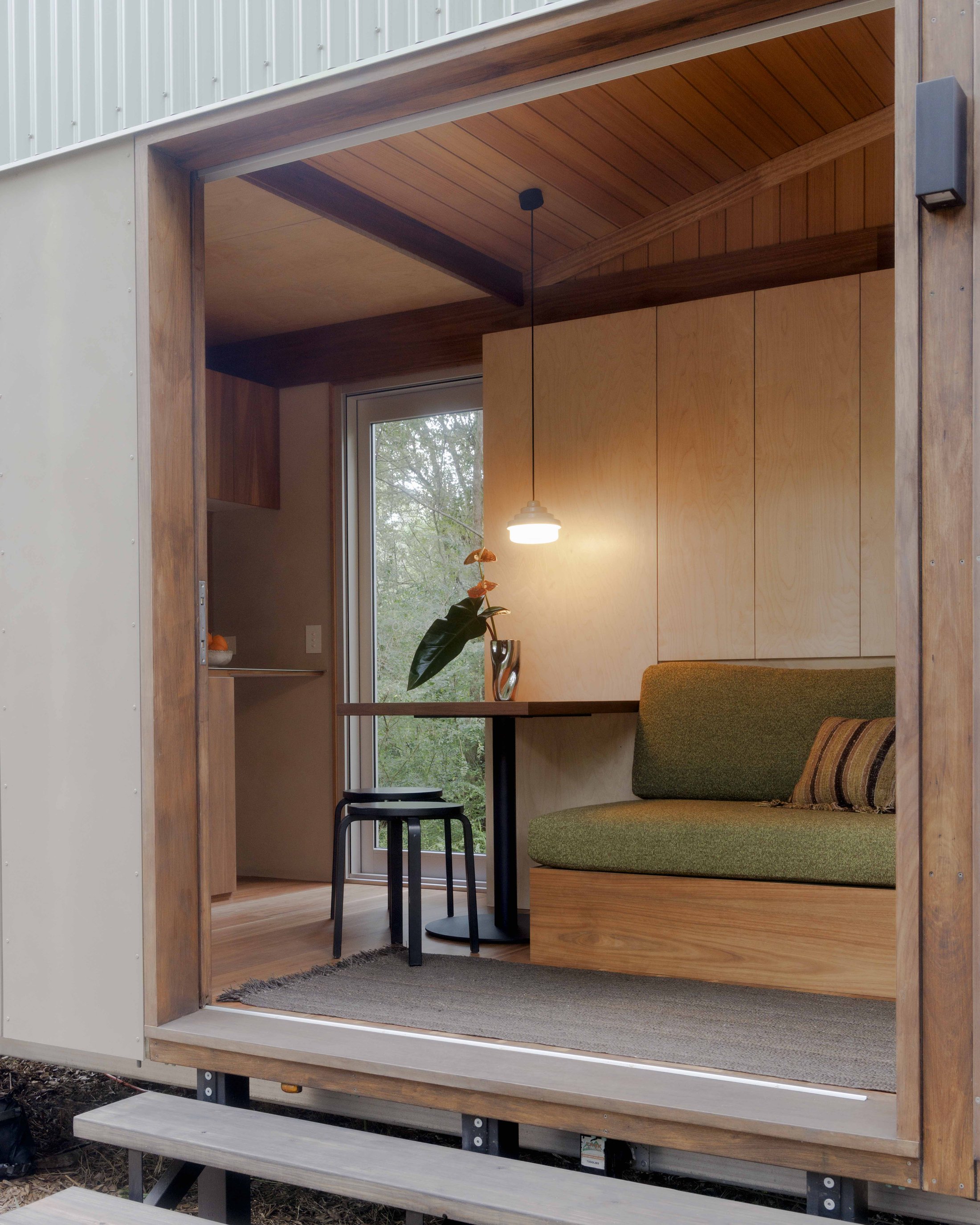 Interior dining nook and kitchen with spotted gum cabinetry and handmade tile splashback